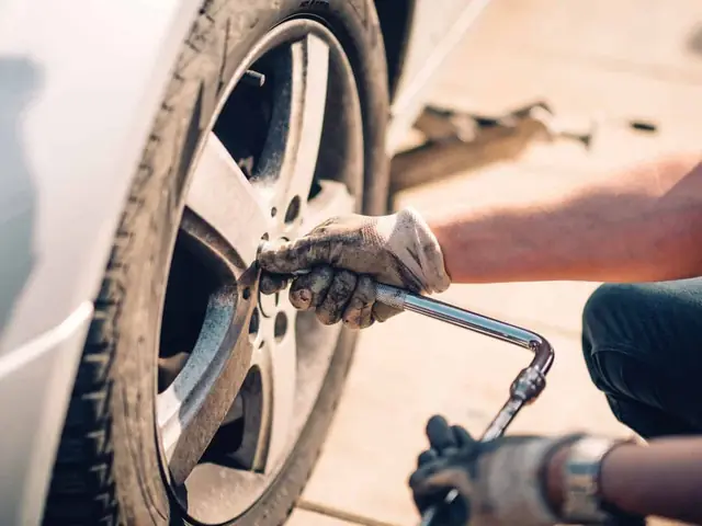 Mobile tyre fitter changing a wheel at the roadside in Hereford